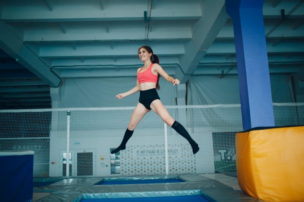 Young woman acrobat jumping on a trampoline Premium Photo